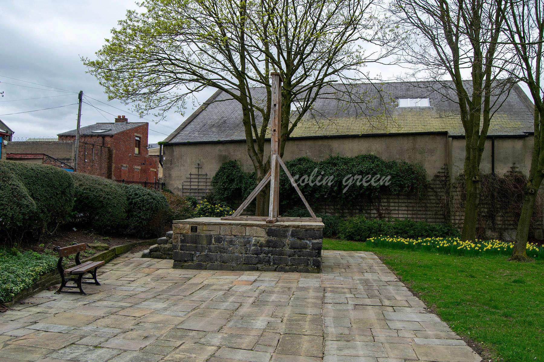 The Halifax Gibbet, an historic form of punishment in a small park surrounded by trees.