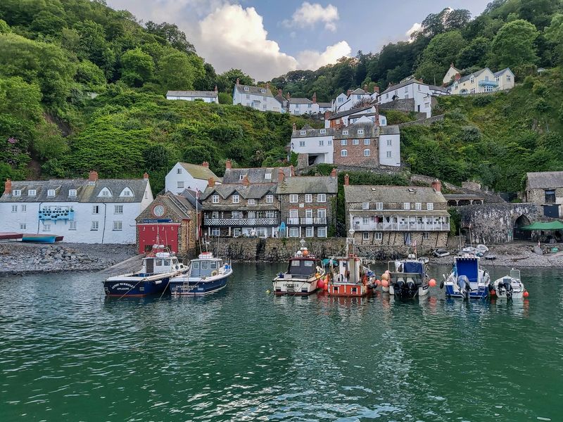 Moored fishing boats at high tide in picturesque harbour of Clovelly in Devon, UK