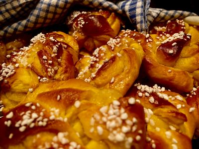 In all of Sweden, Lussekatter (or Luce-cats) is eaten in December and until Christmas. The tradition of baking saffron bread in various forms came to Sweden from Germany in the 18th century. Then we started using yeast in the sweet wheat dough, and with the precious saffron spice, the fluffy cat got both its taste and golden yellow color. The shape of the bread often had its origins in ancient designs. Many landscapes had their own figures and names. Some are inspired by life on the farm, such as kuse (horse) and boar (pig). The name Lussecat (Luce-cat) is much older than the tradition of celebrating Lucia and refers to the fact that the yellow saffron color was considered to protect against Lucifer, the evil one, who, according to folklore, sometimes appeared in the form of a cat. I bake a traditional variant every year (in various shapes) but also this variant filled with vanillabutter (kids favourite). 
 is how to bake them: 
https://www.ica.se/recept/saffransbullar-med-vanilj-714255/